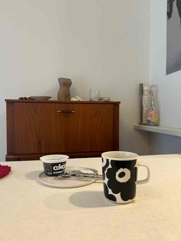 ブラウンのキャビネットとホワイトのテーブルクロスが配置されたシンプルなダイニング空間