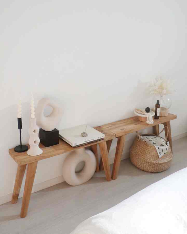 A natural wood tone bench and beige decor objects arranged in a veranda corner of a bedroom with minimalist aesthetic