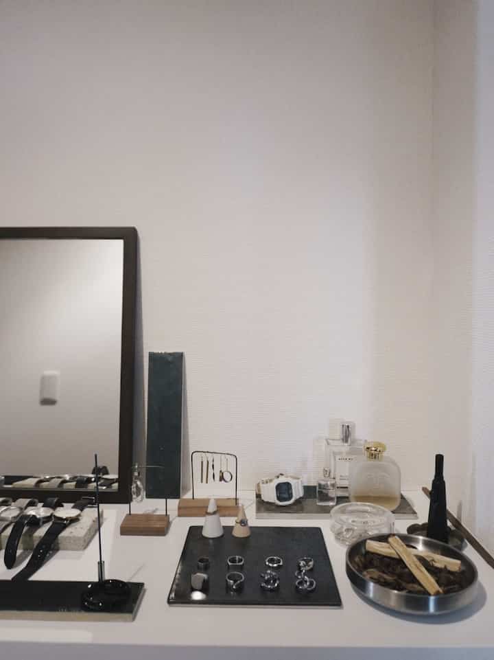 シンプルな白い壁とウッドトーンのアクセサリーが配置された印象的な玄関コーナー