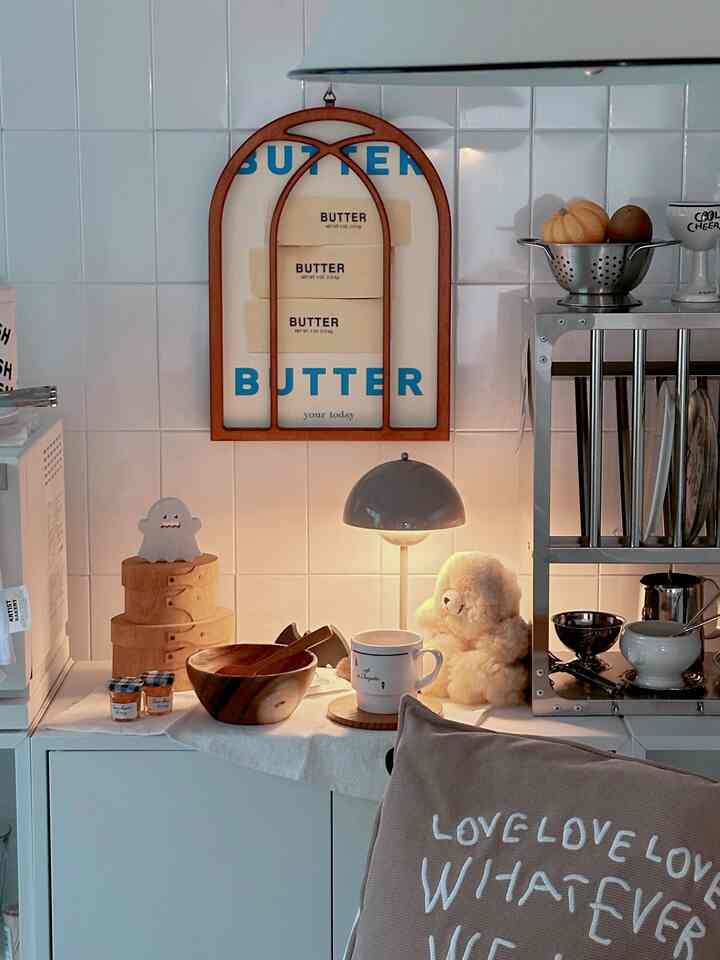 Cozy kitchen cafe-style space with white walls and wood tone accessories, featuring a wall sconce as a focal lighting element