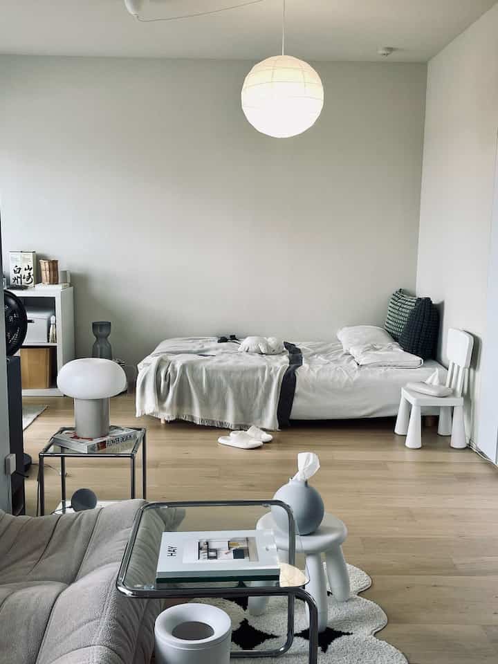 White and wood-tone bedroom featuring pendant light and mid-century modern furniture with a cozy atmosphere