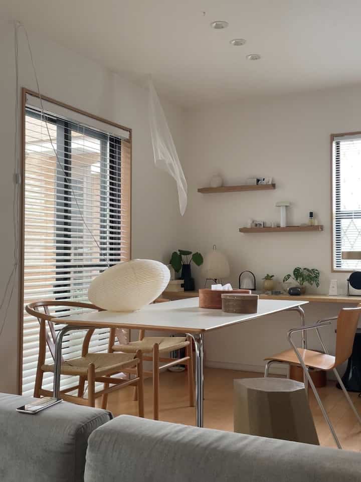 Natural tone dining room with white walls and wooden furniture, featuring simple and minimalistic interior design