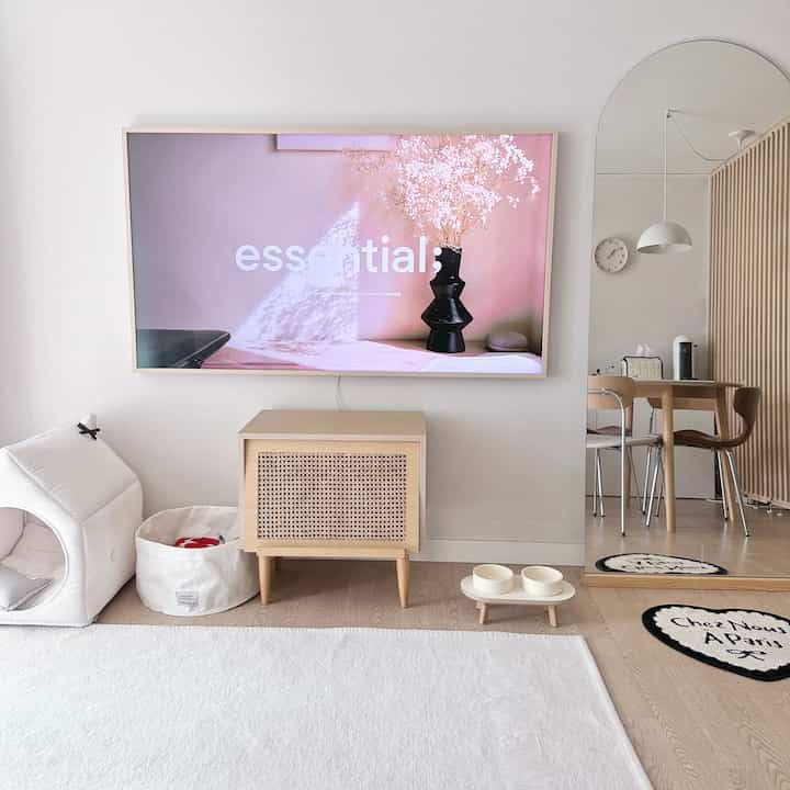 明るいウッドトーンのリビング、テレビ台とペットスペースが配置されたシンプルで居心地の良い空間