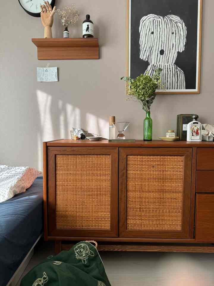Warm brown and beige toned bedroom featuring a central cabinet and wall shelf, creating a natural and cozy atmosphere
