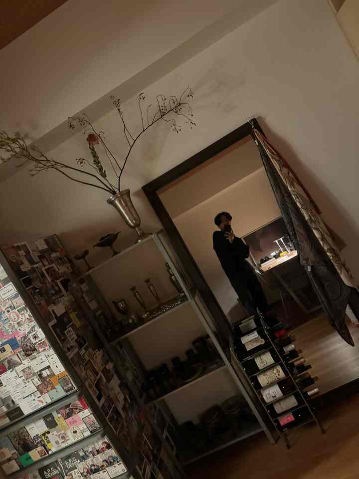 Natural-toned single household living room featuring a large mirror, shelving unit, and wine rack with a cozy atmosphere