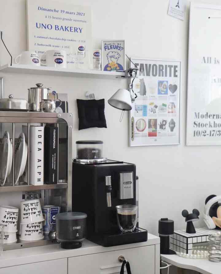 White-toned kitchen space featuring a kitchen rack and a sleek black automatic coffee machine in a simple home cafe corner