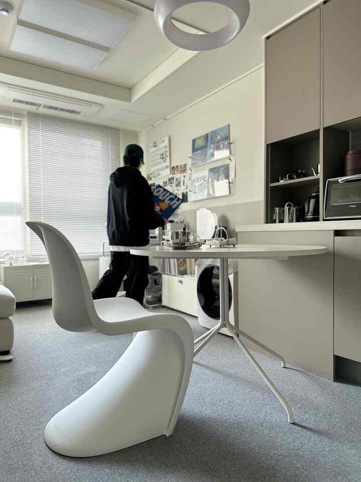 Modern dining room dominated by white tones, featuring a Pantone chair and round dining table creating a cozy atmosphere