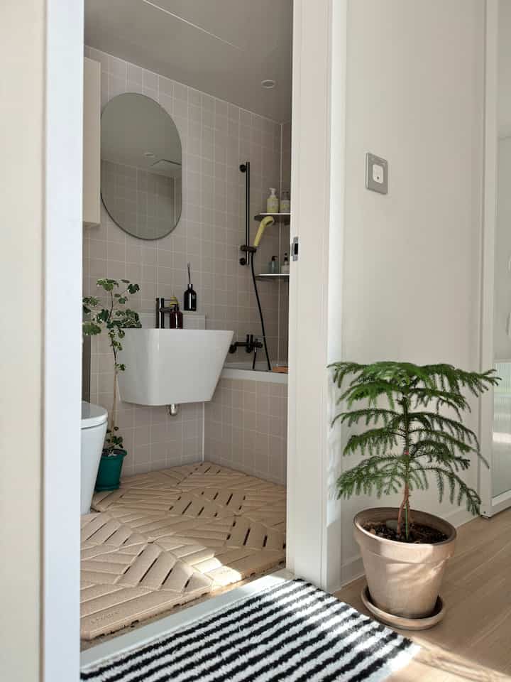 ベージュ色調のドライバスルーム、FOARTのバスマットと白い洗面台が配置された清潔で自然な雰囲気のインテリア