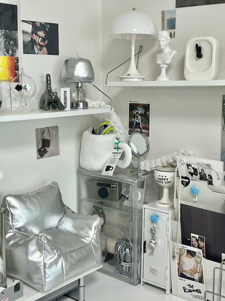Minimal small workspace with white background, silver furniture, and various objets arranged neatly