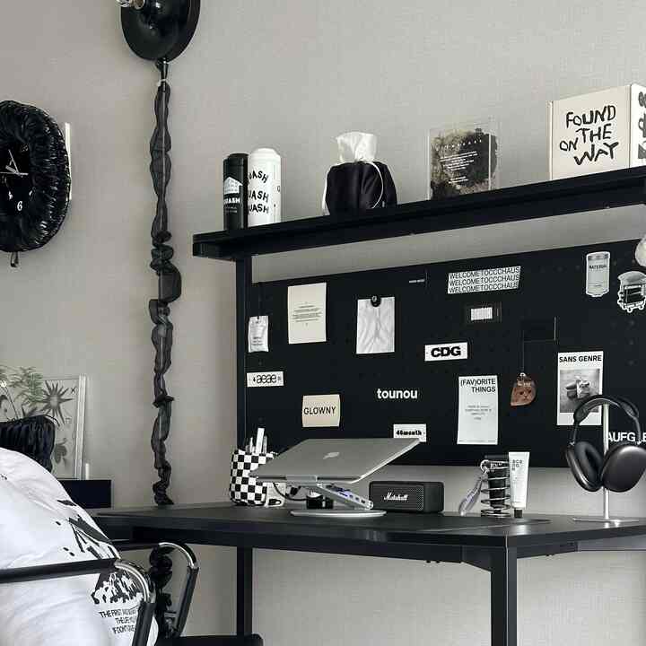 Black and white toned home office featuring a modern minimal desk and headphone stand in a clean workspace