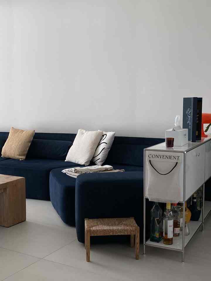 ネイビーのソファとウッドコーヒーテーブルが配置されたシンプルでナチュラルなリビング