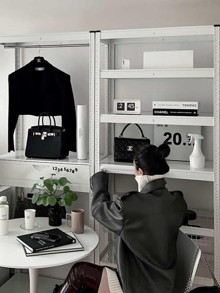 ホワイトとブラックのトーンのダイニングルーム、金属製ラック棚と円形テーブルが調和したモダンでシンプルな雰囲気の空間