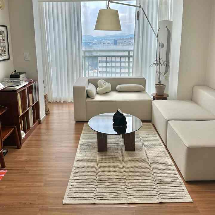 Natural modern 25-pyeong apartment living room with light wood flooring and beige modular sofa