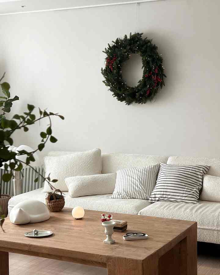 White and natural-toned living room featuring a coffee table, cushions, and a simple warm atmosphere