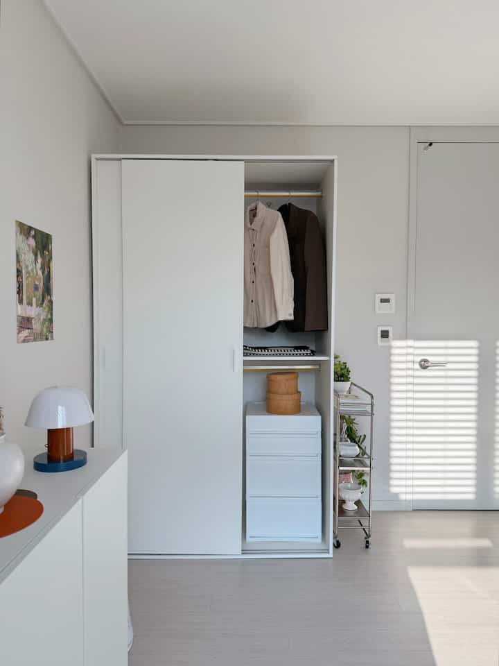 Sliding wardrobe makes even small spaces efficient! 
#Bassporlayer wardrobe

I put a sliding wardrobe in a small room and created my own studio.
I've been married for 15 years, so I've always used the same bedroom and dressing room,
and I've piled up things in one small room like a warehouse,
but I decorated my own space with my favorite dishes, props, paintings, and a wardrobe.

✔️Design and color
White furniture goes well with any props. The matte, clean white is made of the same material for the front, sides, and back, so it looks neat and luxurious without any sense of incongruity when you open the door.

I like the handle that's a good size to hold, because it's comfortable and cute, and it's the focal point of this wardrobe.

✔️Size and performance

The 1200-size wardrobe is a size that can efficiently use space even in a small room in a 20-pyeong apartment. It has two doors and is divided into the upper and lower sections, so you can use a total of 4 compartments, so like me, you can use the lower section as a living box and use it for various purposes such as storing carriers, organizing bedding, and organizing clothes. 

Since it has a sliding door, it is good to use in narrow spaces, and it is a sliding wardrobe recommended for small rooms and one-room apartments. 
The sliding door opens and closes smoothly with a dumping rail, so it is safe because it is quiet and closes smoothly when closed. 

The hanger can also be detached, so you can use the space more efficiently when using it as a bedding closet. 

I really like how the space that used to be dull and empty can be used in various ways and organized neatly with just one sliding wardrobe. 

This is a review after receiving the product through the #FiveSensesReview program and personally using and styling it. 

#wardrobe #slidingwardrobe #quiltcase #1200wardrobe #2400wardrobe #wardroberecommendation #oneroominterior #oneroomwardrobe #smallroomwardrobe #dressingroom #slidingwardrobe #apartmentinterior #whiteinterior #20pyeonginterior #narrowspaceutilization #wardrobeorganization #quiltorganization #quiltcompressionstorage #brandonquiltorganization #livingbox #drawer