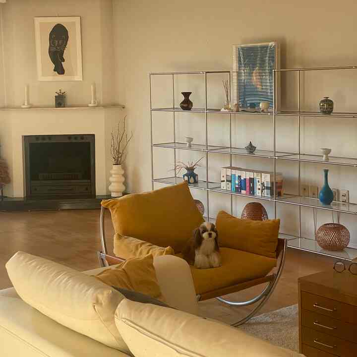 Natural tone living room featuring a warm yellow accent chair and white sofa with cozy atmosphere