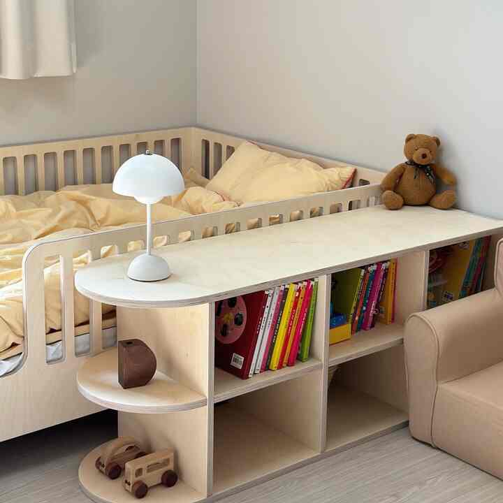 ナチュラルな木目調とベージュの色合いの子供部屋、ノリベッドとサイドシェルフが配置された雰囲気のある空間