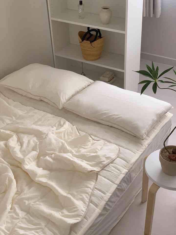White-tone bedroom featuring a simple bed with bedding and minimal interior for a clean space