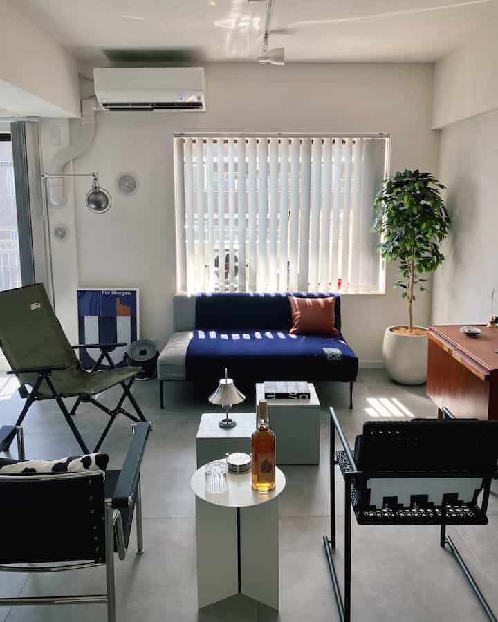 White and navy toned living room featuring simple layout with modern sofa and armchairs arranged in a cozy setting