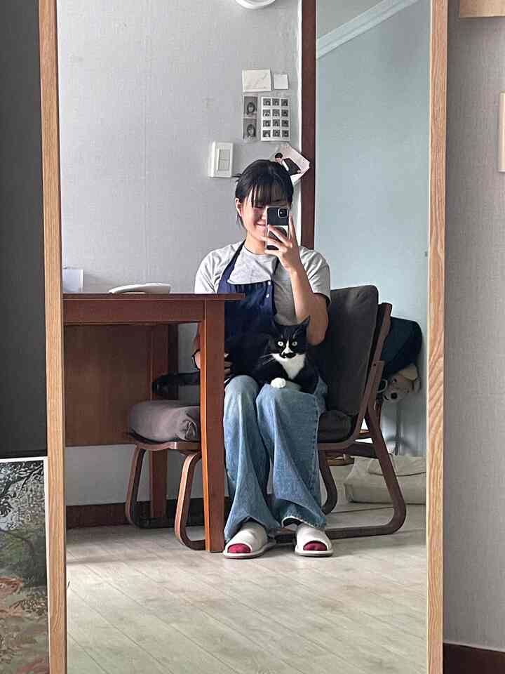 ナチュラルな色調のリビング、巨大な鏡と木製のダイニングテーブル＆チェアが配置された落ち着いた雰囲気の空間