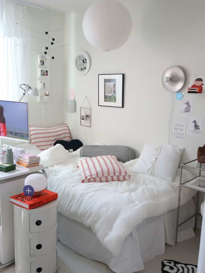White-toned compact, simple modern bedroom featuring a white bed and desk creating a cozy space