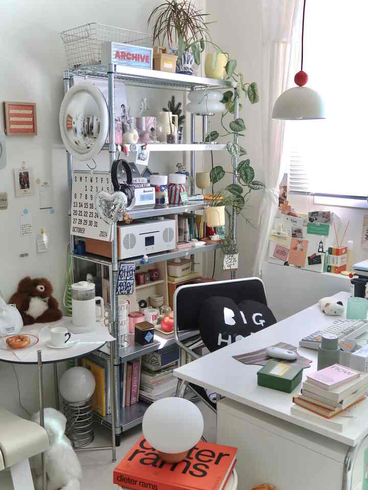Small room with white and gray tones, featuring modern desk and storage shelves for remote work setup