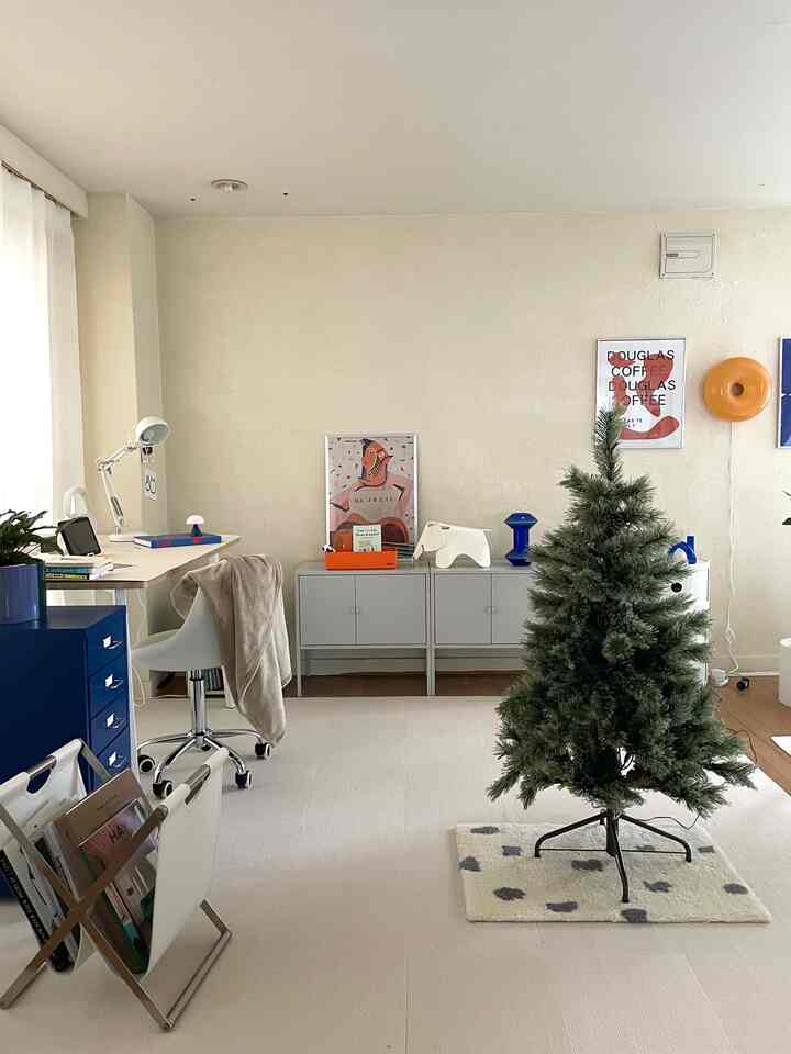 明るいホワイトとベージュのトーンの1LDKリビング、ミッドセンチュリーモダン家具とクリスマスツリーが配置された雰囲気のあるインテリア