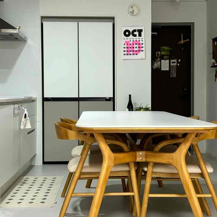 白と木目調のキッチン空間、木製のダイニングテーブルとチェアが配置された明るくシンプルなインテリア