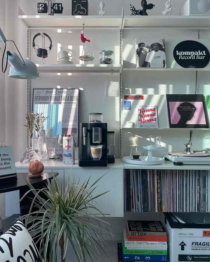 白を基調としたモダンなキッチン兼オーディオスペース、コーヒーマシンとレコード棚が配置されたシンプルなおうちカフェインテリア