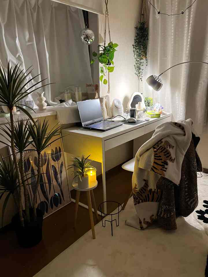 白色調のホームオフィス空間、植物が配置され温かみのあるベージュのカーペットが特徴的なインテリア