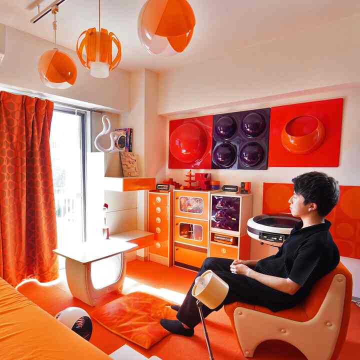 Orange-toned retro living room featuring unique pendant lights and Mid-Century Modern inspired furniture with a vibrant atmosphere