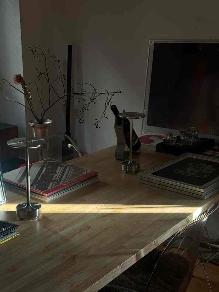 ナチュラルな色調の1LDKダイニングルーム、透明な椅子と真鍮のテーブルランプが置かれた落ち着いた雰囲気のインテリア