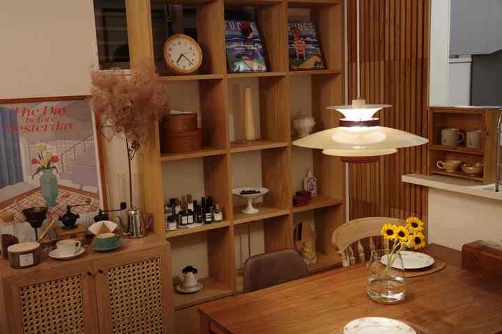 木目調とベージュのダイニングルーム、ペンダントライトとひまわりの花瓶が配置されたナチュラルなインテリア