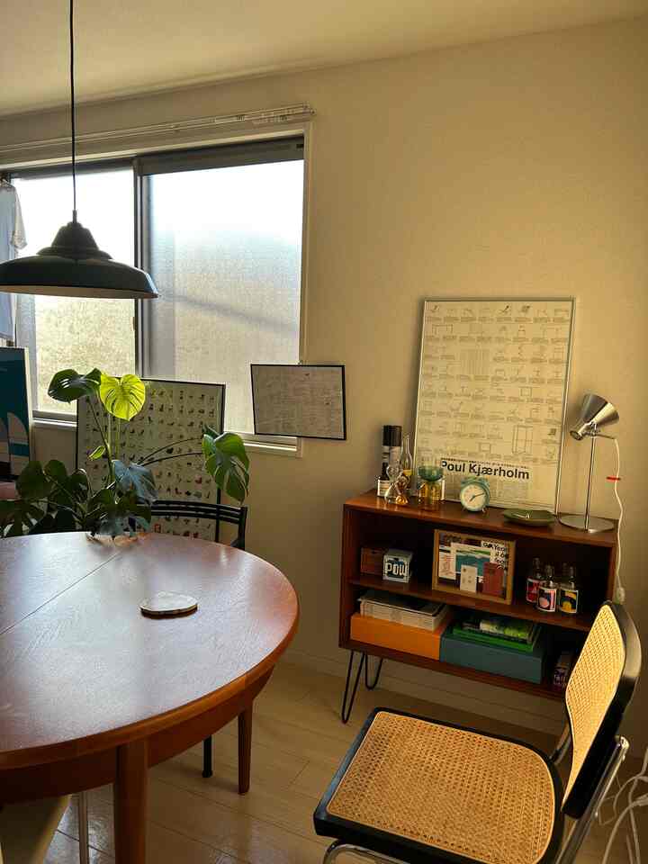 木目調とベージュ壁のダイニング、ラウンドテーブルとラタンチェアが配置された温かみのある自然な雰囲気のインテリア