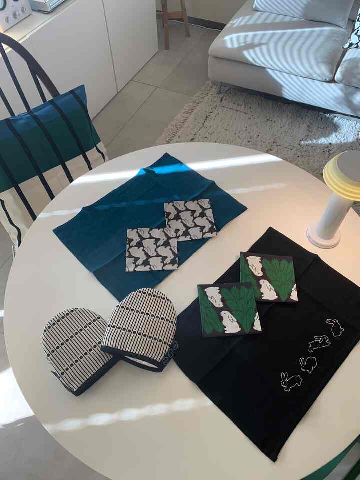 Natural style dining room featuring a white round dining table with teal cushions and rabbit patterned placemats