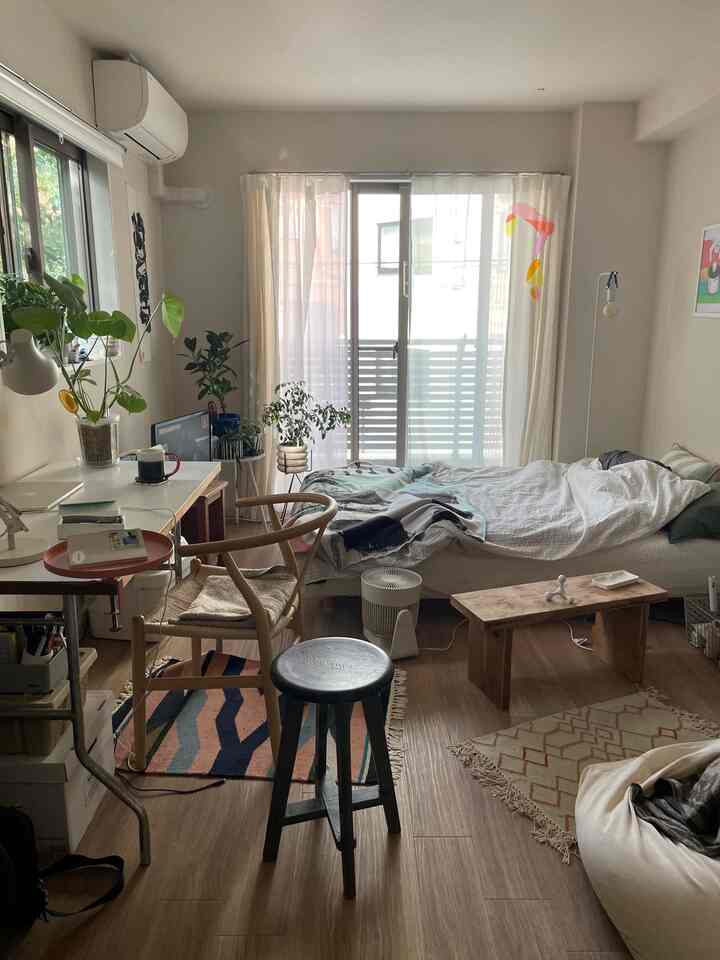 White and wood tone 1K single household bedroom featuring a desk, bed, and plants creating a natural atmosphere.