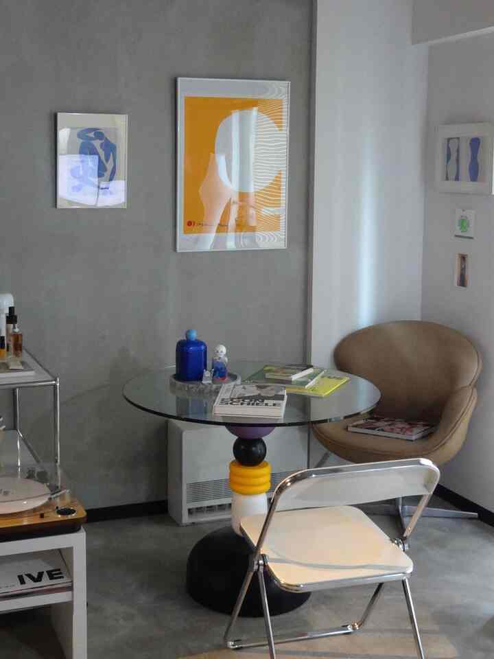 グレーとベージュの落ち着いた色調の一人暮らし用ダイニングルーム、透明なガラスのダイニングテーブルとシンプルな椅子が配置された印象的な空間