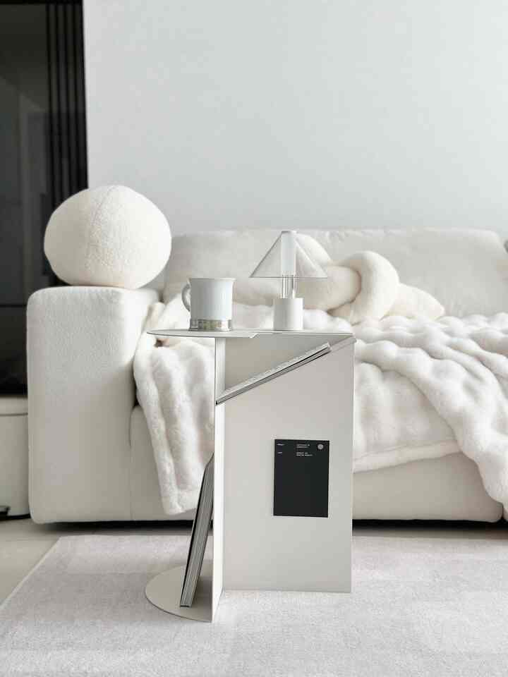 柔らかな白を基調としたリビング、丸みのあるソファと白いサイドテーブルが配置された雰囲気のあるインテリア