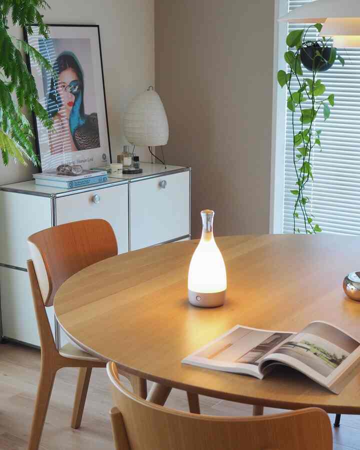 ナチュラルな木目調と白が調和するダイニング、ラウンドテーブルとチェアが配置された雰囲気のある空間