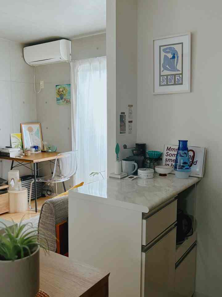 White and wood tone kitchen and living space featuring a marble-look counter and transparent acrylic chair in a modern, simple interior
