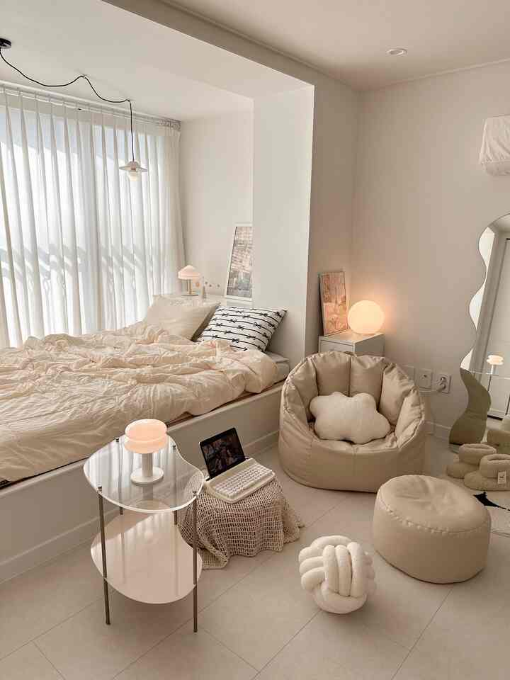 柔らかいベージュとホワイトのトーンの寝室、枕とクッションが配置された穏やかな雰囲気のあるインテリア