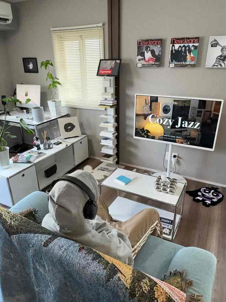 青いソファと白い壁、サイドテーブルが配置されたモダンなリビングの印象的な空間