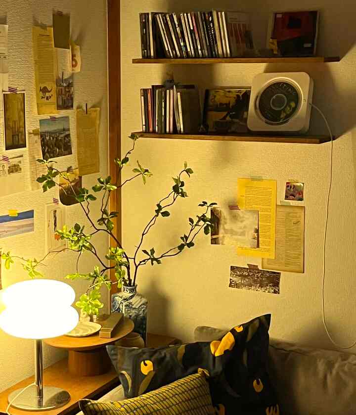 Natural color corner living space featuring sofa, wooden furniture, and table lamp with cozy atmosphere