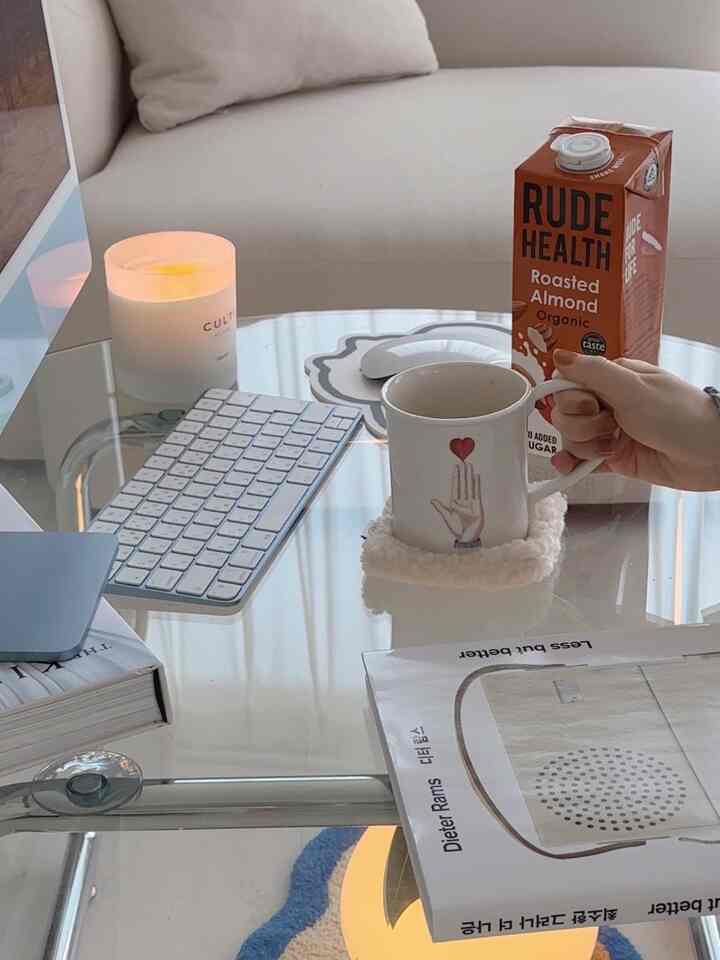 白とスカイブルーのトーンのリビング空間、ガラステーブルにコーヒーカップとキャンドル、キーボードが配置されたモダンなホームカフェ雰囲気のインテリア