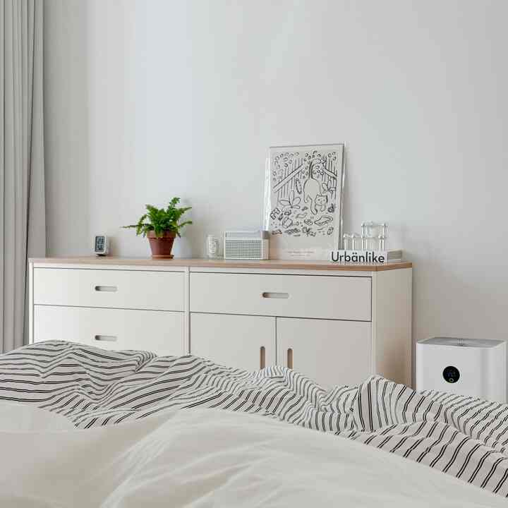 白い壁と木目調の天板があるナチュラルな寝室、ペットの猫の絵画が印象的で落ち着いた雰囲気のインテリア