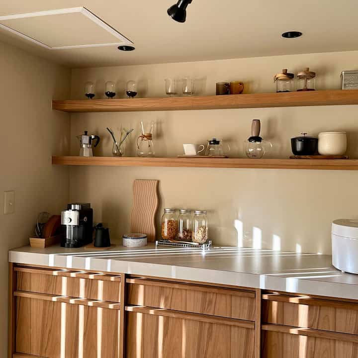 棚と収納はチークの木材を使っています🪵🪵
天板の下はかなり大容量の収納になっているので、
見た目の良さと使い勝手を両立できていると思います💭

また、飾り棚の裏には間接照明💡を仕込んでいまして…
昼はカフェ☕️夜はバー🌉のようなイメージになります！

#リノベーション #マンションリノベーション #マンションリノベ #マンションリノベーション事例 #中古マンションリノベーション #中古マンションリノベ #リノベーション事例 #リノベ事例 #ベージュインテリア #ベージュキッチン #リノベーション住宅 #ベージュの家 #塗装壁 #キッチンリノベーション #無垢材家具 #間接照明 #間接照明のある暮らし #カフェのような家 #カフェ風キッチン #見せる収納 #見せる収納棚 #チーク材家具 #コーヒーのある暮らし
