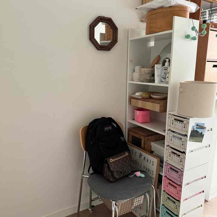 白い壁と木目調の小物が調和するウォークインクローゼットのコーナー、イケアの本棚と多様な収納ボックスが整然と配置された空間