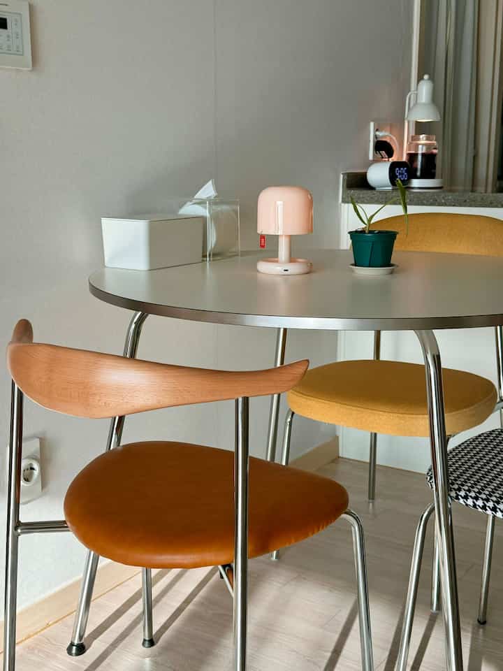 White and wood-toned mid-century modern dining room with minimalist decor and calm atmosphere