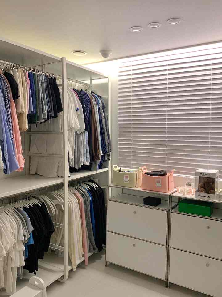 白を基調としたウォークインクローゼット、イケアのエルヴァーリハンガーとモジュラー収納キャビネット、多彩な収納バスケットが整然と配置された空間