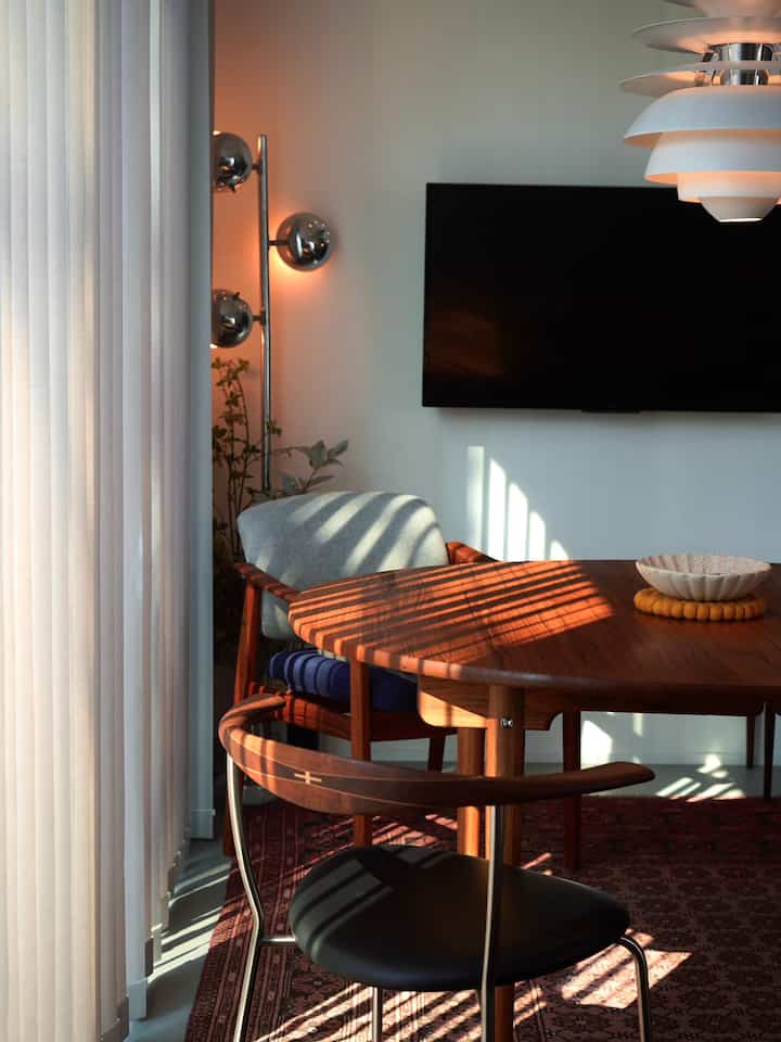 白い壁と木目調のラウンドダイニングテーブルがある北欧スタイルのダイニングルーム